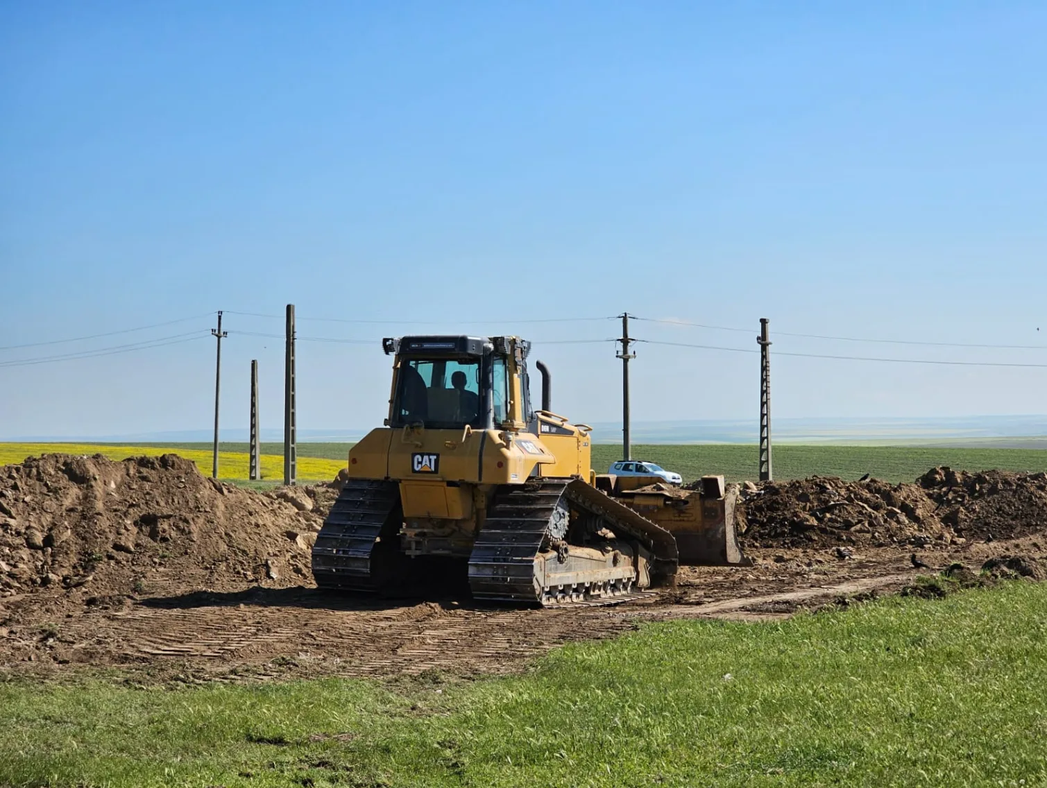Buldozer CAT lucrând la nivelarea terenului